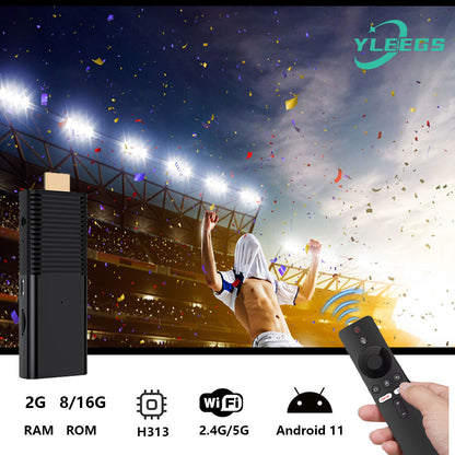 Close-up of the YLEGS I96D1 Android TV stick with a sleek black design, connected to a remote control, showcasing its compact size and features like 2.4G/5G WiFi, 8/16GB ROM, H313 processor, and Android 11, perfect for streaming and transforming your TV into a smart entertainment hub against a vibrant stadium background with confetti and cheering crowd.